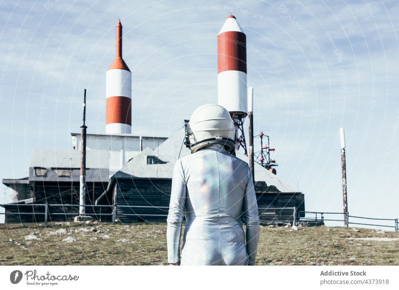 Cosmonaut against rocket shaped antennas man cosmonaut astronaut spaceport concept explore future innovation mission male fence protect safety spaceship