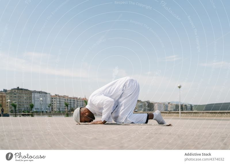 Islamic man praying on mat on beach - a Royalty Free Stock Photo from ...