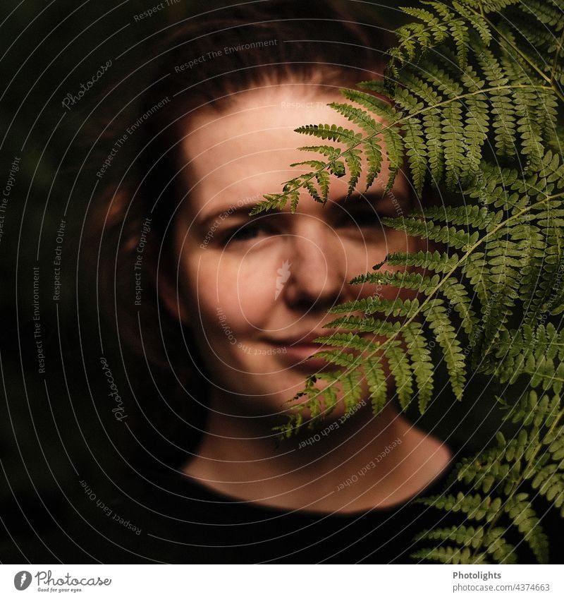 Young woman hiding behind a fern leaf portrait Shadow Light Day Exterior shot Colour photo Fern Human being 1 Face Adults Woman 18 - 30 years Feminine