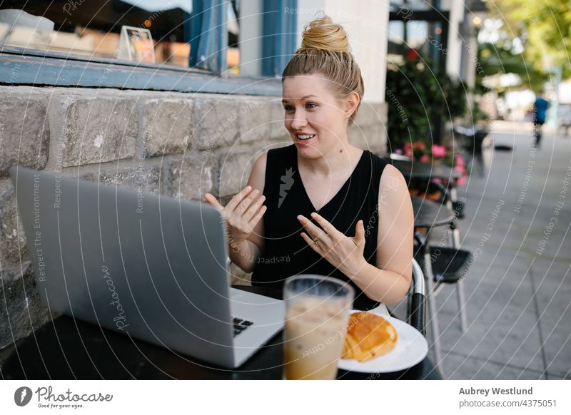 Young professional woman on a conference call at an outdoor coffee shop 25-30 30-35 years adult american blogger blonde boss cafe caucasian comference call