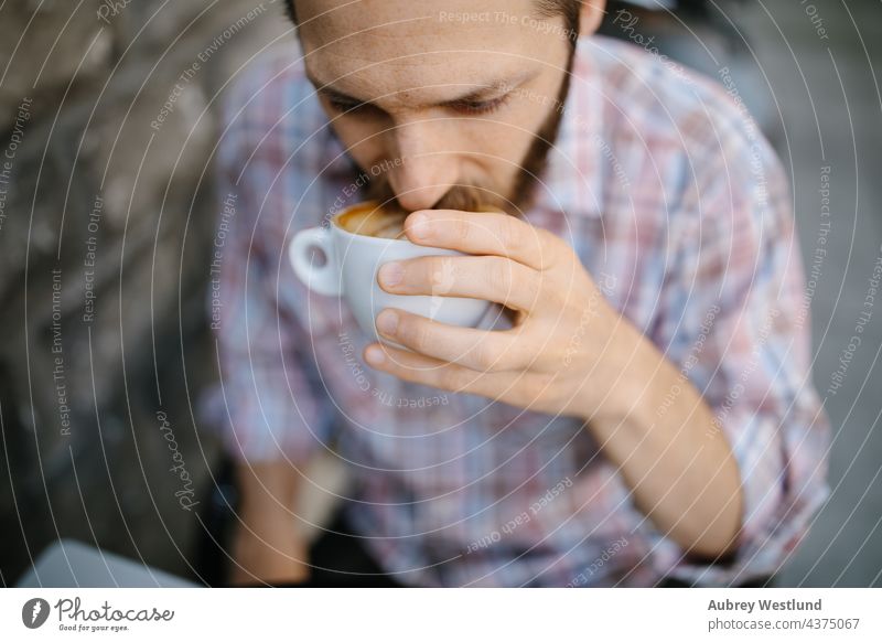 Young man drinking coffee at an outdoor coffee shop 25-30 30-35 years adult american beard bearded blogger boss brunette business owner cafe california