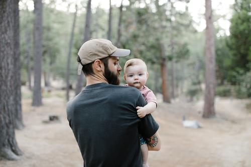 father carrying his baby daughter on a walk through the woods 25-30 30-35 30-40 beard bonding california camp camper camping campsite caucasian chair child