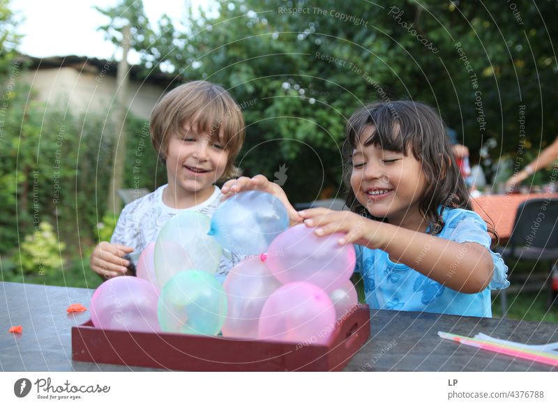 children having a great time playing with baloons pursuit of happiness pursuit - concept positive emotion Playful people multi colored baloons love - emotion