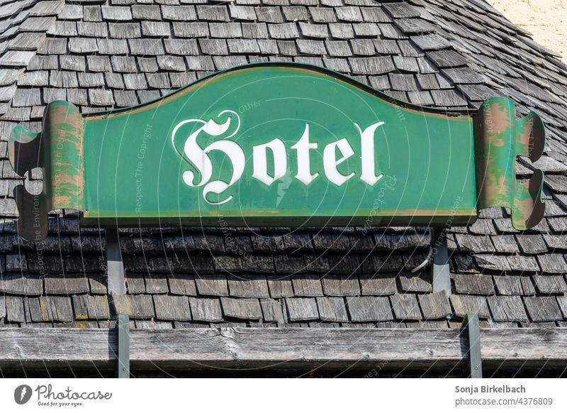 sign hotel- weathered on a shingle roof - concept holiday, tourism, vacation in the alps Hotel Roof Shingle roof holidays Alps mountains Exterior shot