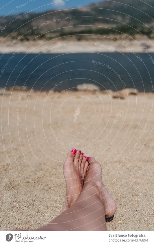 unrecognizable woman feet lying on sand during summer time. vacation and relax concept young weekend pedicure travel caucasian toenail sunbathe background happy