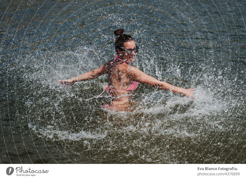 happy caucasian woman swimming in lake and splashing. summer time. fun outdoors active sunlight young healing recreation fitness dip travel beauty sauna pool
