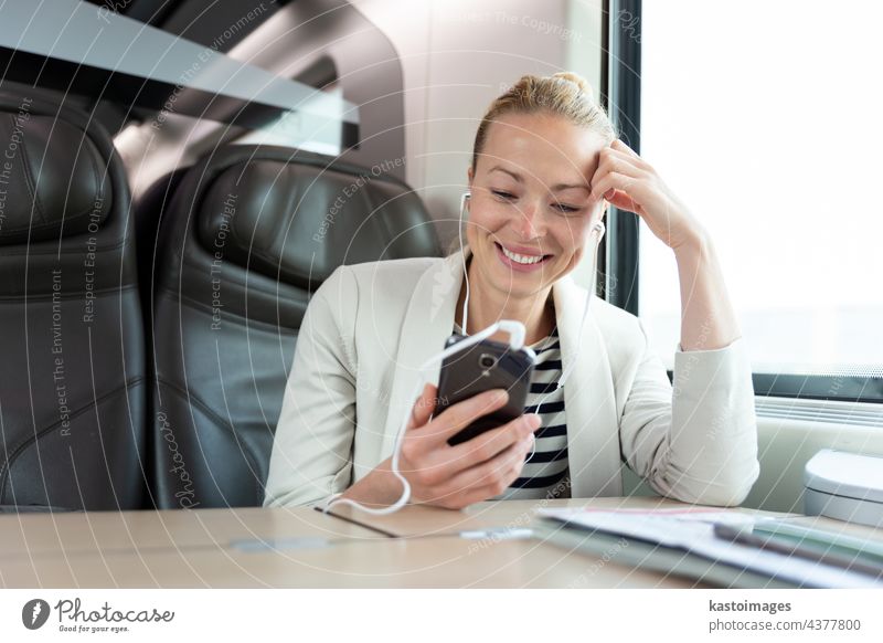 Businesswoman communicating on mobile phone while traveling by train. business businesswoman modern person professional sitting smart communication technology