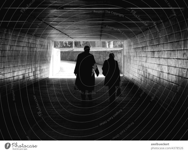 Silhouettes of couple walking through pedestrian tunnel Shadow Couple Unrecognizable Pedestrian Underpass Tunnel Dark Architecture Going Lanes & trails Light
