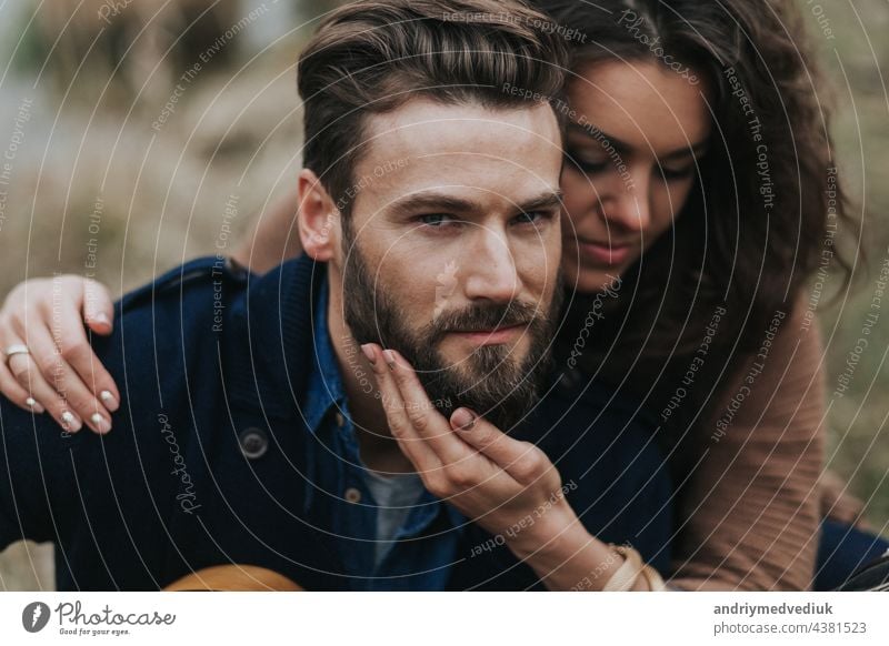 portrait of two caucasian lovers. Young couple is hugging on autumn day outdoors. A bearded man and curly woman in love. Valentine's Day. Concept of love and family.