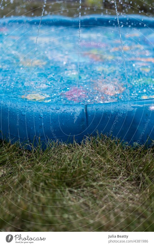 Hot summer day activity; water in splash pad sprinkler toy in the grass pool baby pool wade spray vinyl inflate water park fountain sprayground play explore