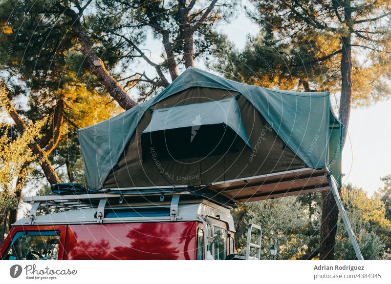 Rooftop tent for camping on the roof rack of and off-road SUV car in a natural park rooftop 4x4 vacation nature transportation adventure travel truck remote