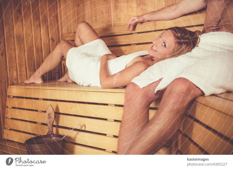 Couple relaxing in traditional wooden Finnish sauna. woman wellness spa well being beautiful adult beauty beauty center bench body body care bucket candle