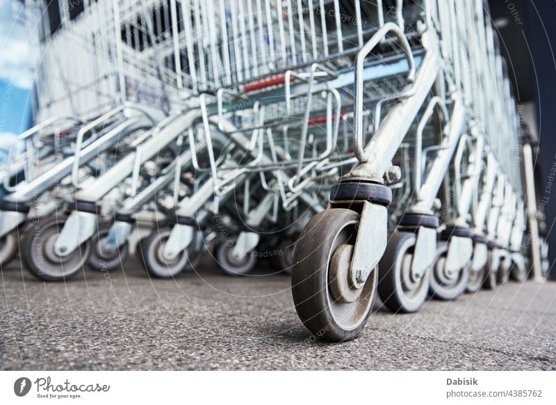 Row of empty shopping cart near a shop, close up supermarket basket retail store buy business background trolley grocery metal sale consumer purchase customer