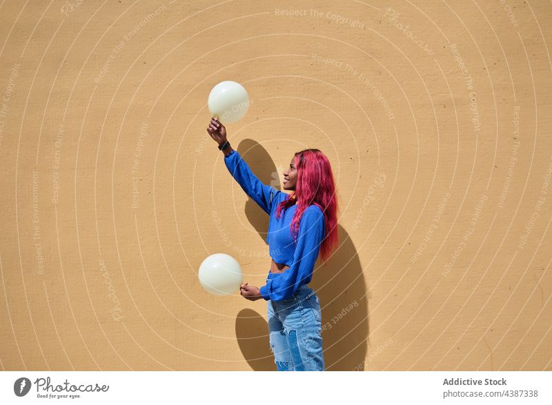 Ethnic woman with balloons near wall style color dyed hair happy trendy fun hipster look bright colorful female young african american black ethnic cheerful