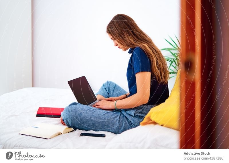Happy woman working on laptop at home using remote digital online freelance bed female young student communicate typing browsing gadget internet device blogger
