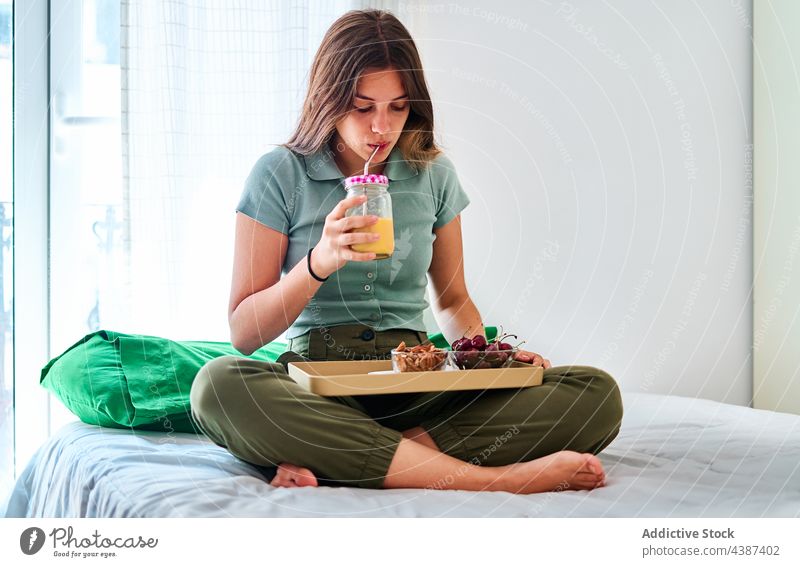 Woman having breakfast in bedroom woman at home healthy juice morning drink natural fresh female young beverage food lifestyle berry fruit vitamin wellness