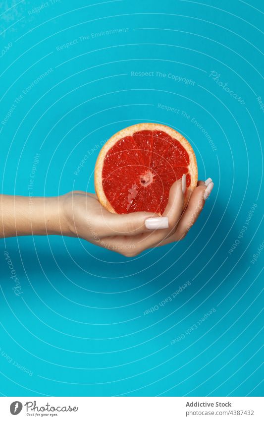 Woman with grapefruit in hand half slice fresh natural juice healthy citrus female vitamin ripe organic food tropical red cut manicure nail bright pulp