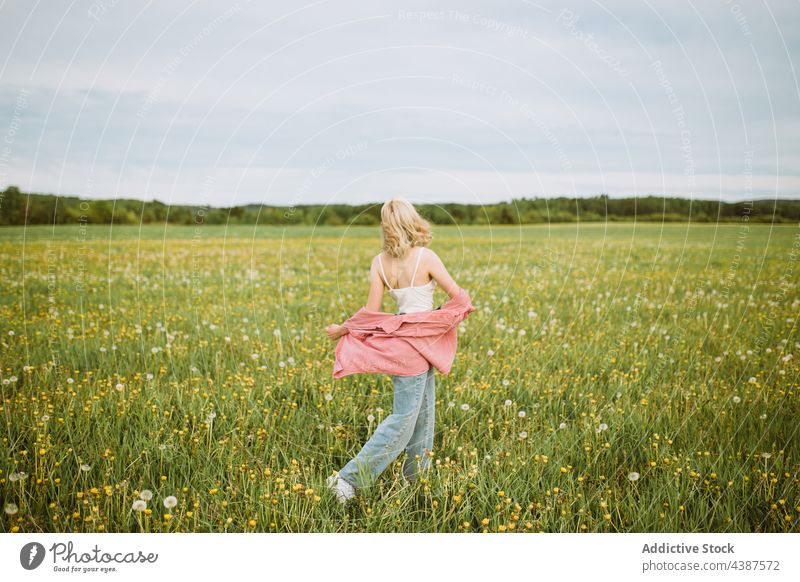 Unrecognizable carefree woman walking in blooming field summer freedom meadow flower blossom female enjoy nature countryside harmony grass green idyllic