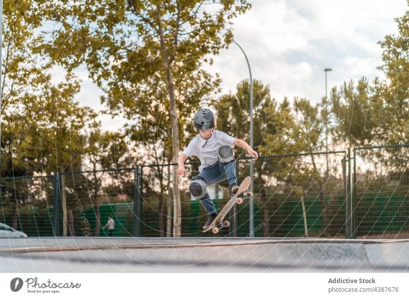 Skater performing trick on ramp in skate park boy skater jump skateboard stunt extreme teenage activity energy above ground brave risk adrenalin hobby urban