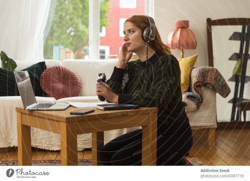 Anonymous woman recording podcast at home microphone speak headphones broadcast talk laptop using female host radio audio blogger headset work gadget sound tune