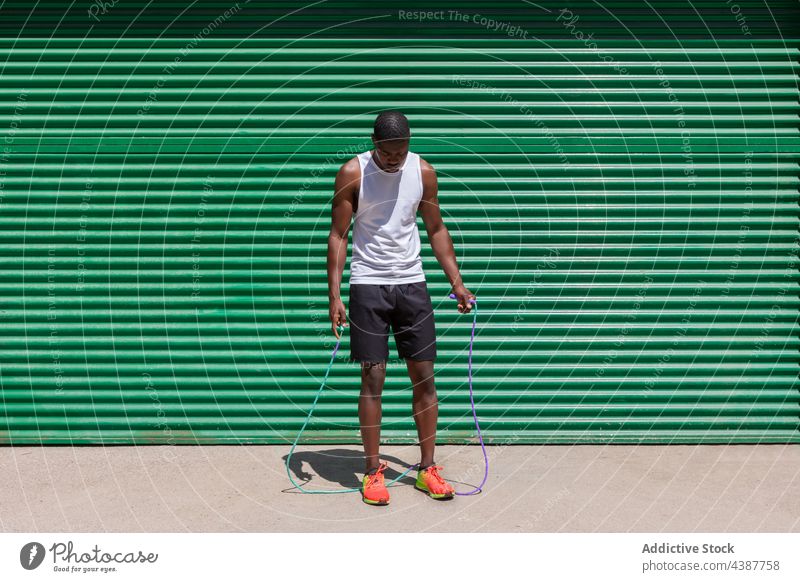 Black fit sportsman jumping rope during training black skip cardio exercise workout athlete city male ethnic african american summer activity vitality wellbeing