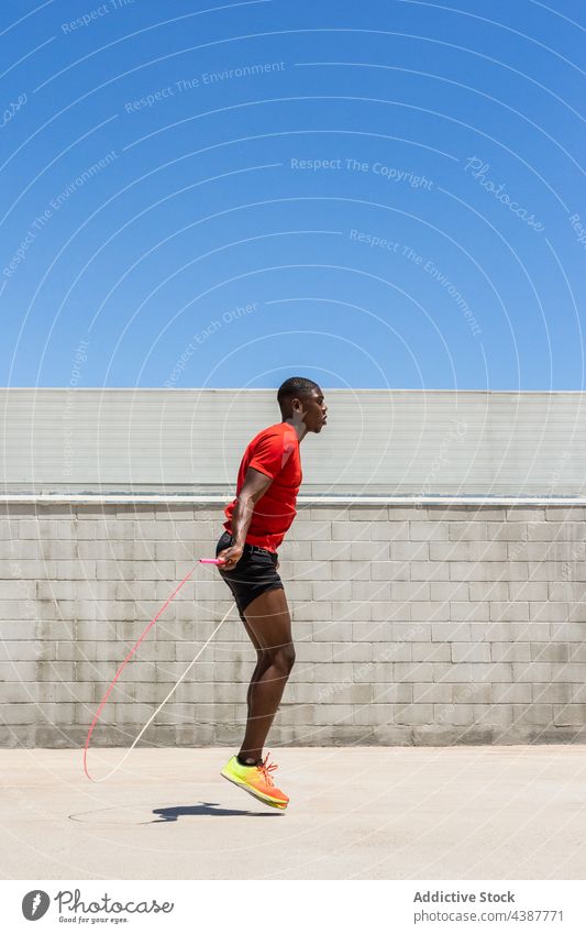 Fit black sportsman jumping rope during workout moment cardio exercise active energy athlete training male ethnic african american fitness skip leap activity