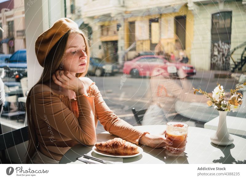 Woman with coffee and croissant at table in cafe woman dessert delicious tasty drink beverage female french aromatic fresh enjoy beret pastry sweet food