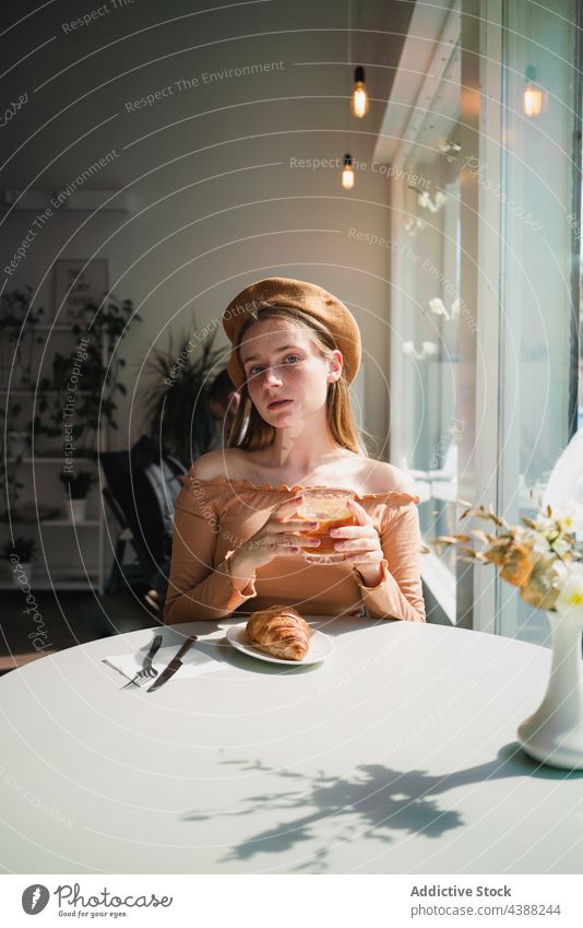 Woman with coffee and croissant at table in cafe woman dessert delicious tasty drink beverage female french aromatic fresh enjoy beret pastry sweet food