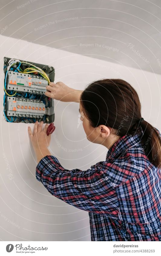 Electrician working on the distribution panel of a house woman unrecognizable electrical technician electrician electrical installation inspection testing