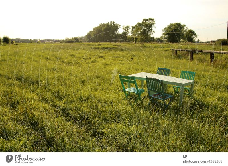 deserted table and chairs on a field with grass Empty Lonely sunny Summer Meadow Table Break Day Seating Wooden chairs Tourism coronavirus Closed nobody