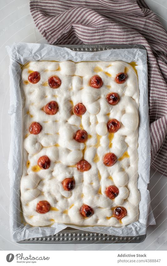 Delicious focaccia with sun dried tomatoes garnish cook prepare raw dough process bread tradition baking paper dish homemade kitchen food table bakery cuisine