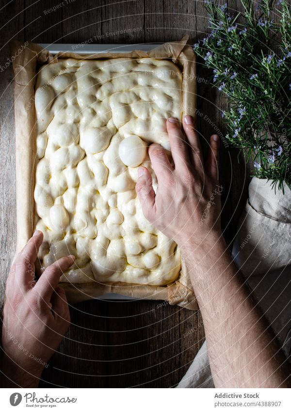 Crop cook preparing dough for cooking traditional focaccia prepare raw person process bread baking paper dish homemade kitchen food table bakery cuisine fresh