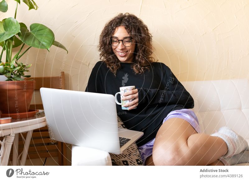 Woman with coffee and laptop resting at home woman pensive drink chill dream thoughtful young hispanic ethnic female relax comfort lifestyle cozy lounge cup