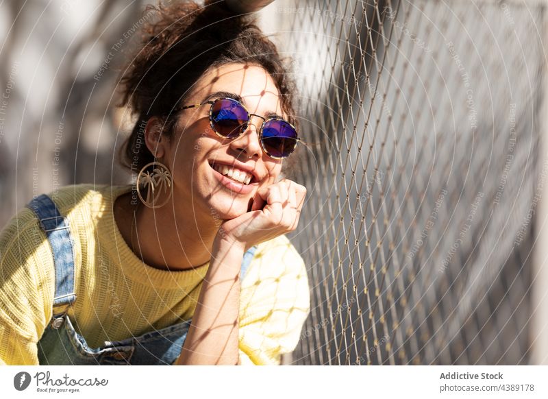 Stylish happy young woman in sunglasses style trendy fashion accessory modern urban sunlight millennial female eyewear denim yellow curly hair hispanic ethnic