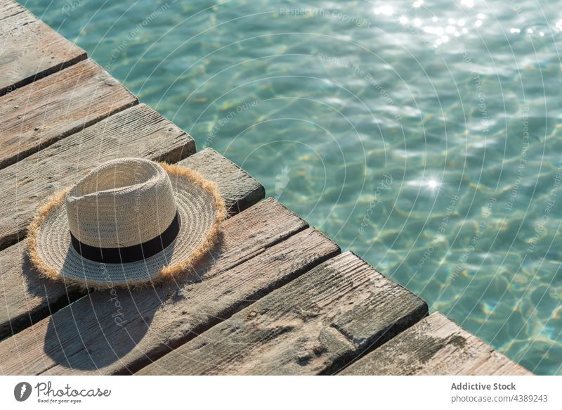 Straw hat on wooden pier near sea straw hat sunhat summer accessory quay sunny shore playa de muro alcudia mallorca spain vacation seashore seafront waterfront