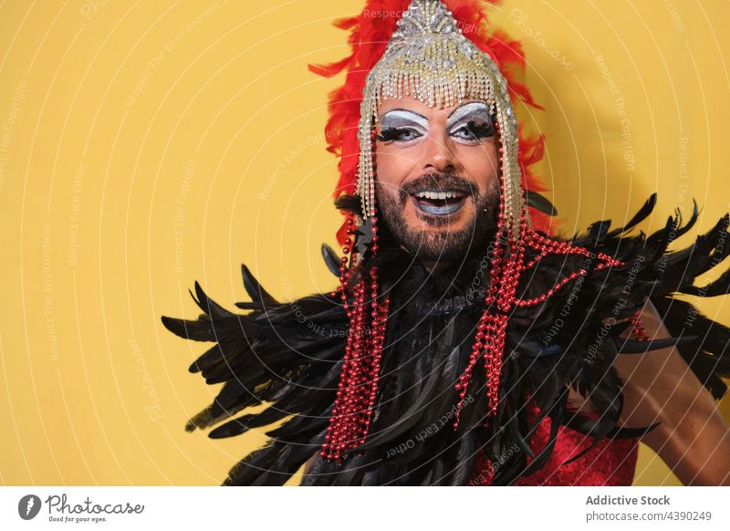 Drag queen model in bright costume man drag queen makeup outfit headdress wear gender feather transgender accessory headwear headgear feminine cloth extravagant