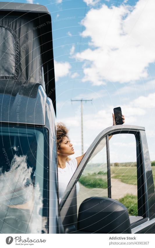 Woman with smartphone in broken car woman camper trouble problem connection driver traveler female young african american black ethnic mobile trip gadget using