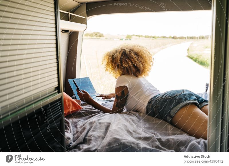 Ethnic woman chilling in camper van laptop using rest summer traveler holiday female african american black ethnic young vacation curly hair movie browsing