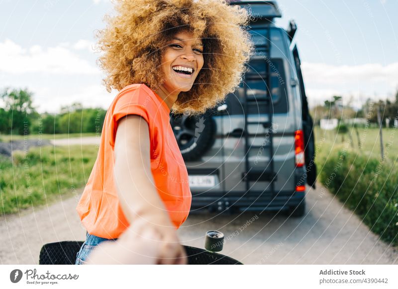 Black female traveler leading friend to camper woman road trip follow me smile summer countryside together longboard van happy ethnic black african american