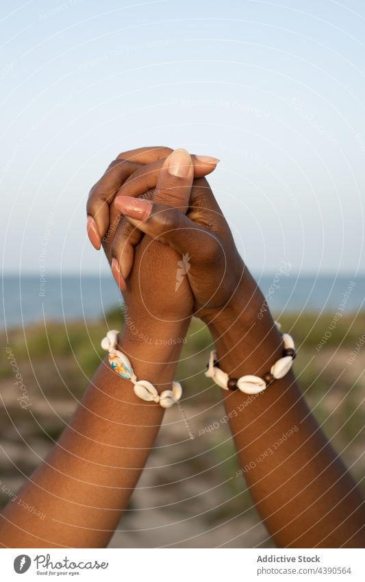Black girlfriends holding hands together on seashore women friendship summer bracelet shell best friend relationship beach unity love support sister lgbt