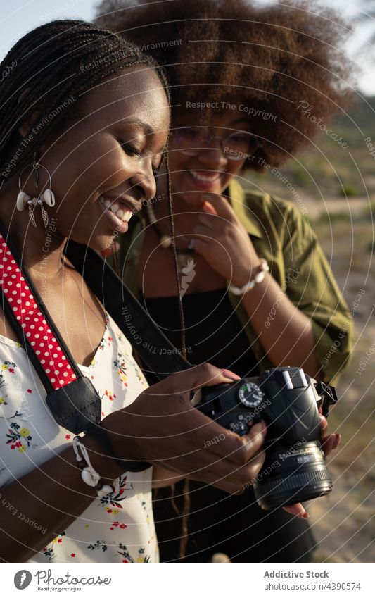 Happy black girlfriends with photo camera in summer nature happy together style cheerful vacation holiday young women african american ethnic best friend trendy