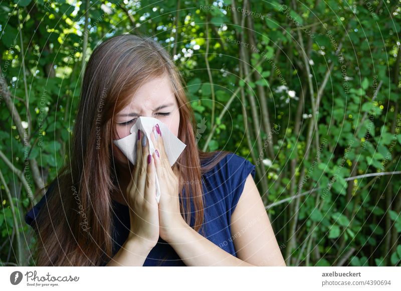 young woman with hay fever blows her nose with paper handkerchief Hay fever sniffles blow one's nose Handkerchief Nose polish Allergy Blow one's nose