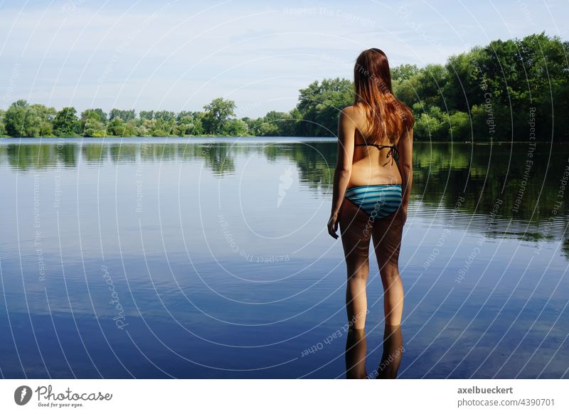 young woman in bikini stands in water and looks at lake Young woman Bikini Lake Swimming lake swimming pond Pond Nature bathe Swimming & Bathing Water Summer