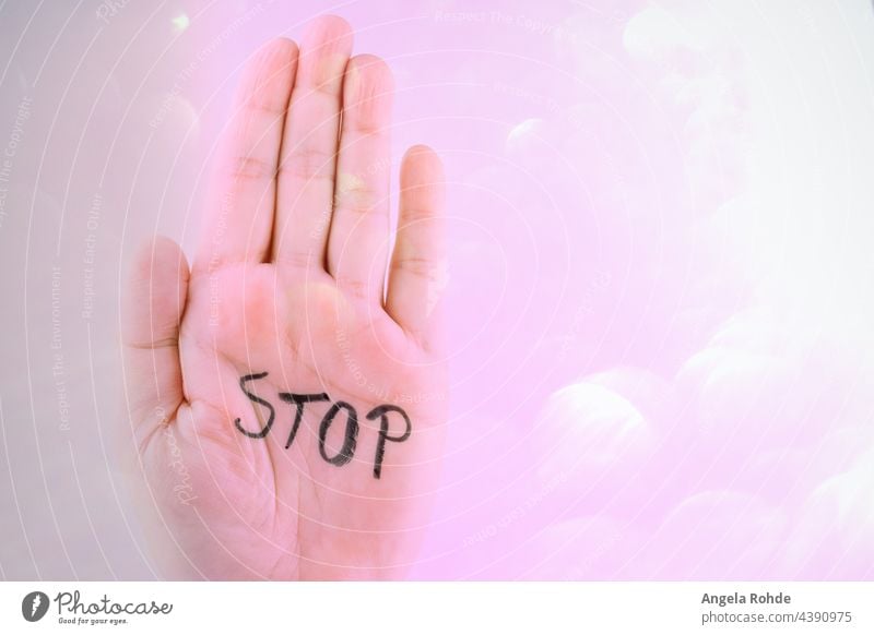 Raised hand with the word Stop in the inner surface, pink background stop sign woman white isolated symbol gesture concept people female warning human painted