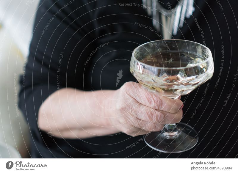Woman holds a glass of champagne in her hand woman holding toast raise pledge birthday drink bubbly sparkling wine brisk event celebration party human arm black