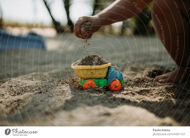 Child playing with sand and truck Playing Truck Toys Sand conceptual Construction site Construction machinery Colour photo Day Exterior shot Work and employment