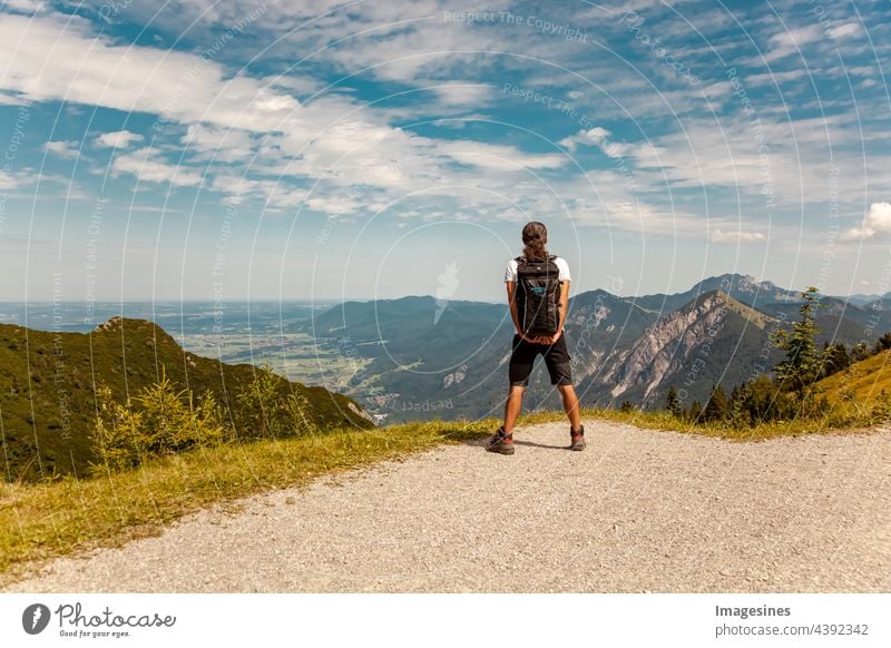 Male backpacker looking at the spectacular Bavarian mountains. Man hiking in the mountains. Hiker with backpack at Herzogstand in the Bavarian Alps. active