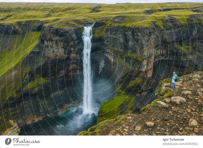 Aerial view of woman with backpack enjoying Haifoss waterfall of Iceland Highlands aerial haifoss tourist travel nature mountain iceland stream cliff tourism