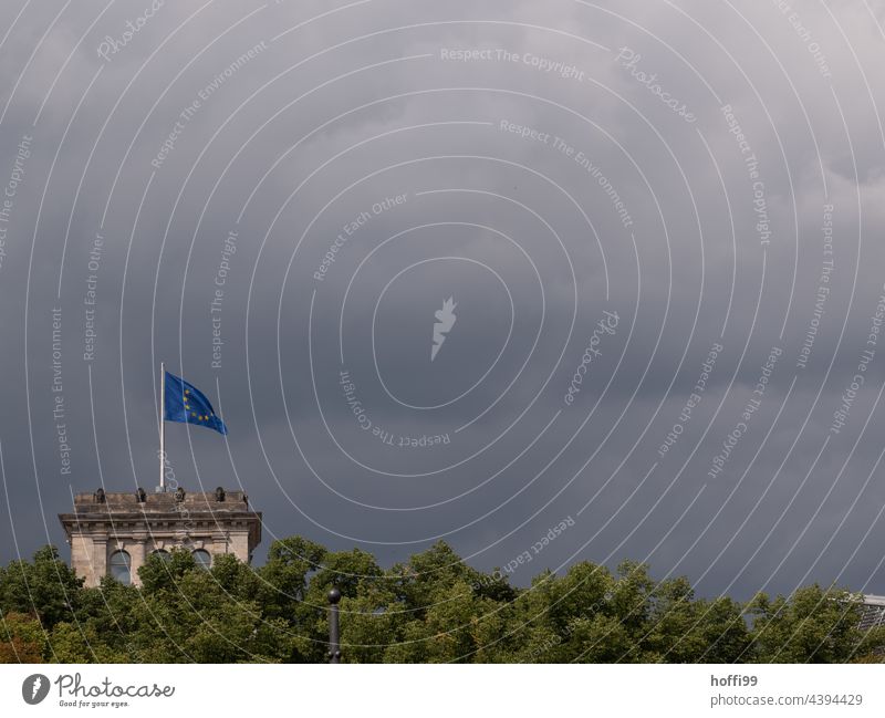 European flag on the Reichstag in Berlin during upcoming storm - stormy times Flag Blow Star (Symbol) Politics and state Landmark Wrinkles Yellow Blue Storm