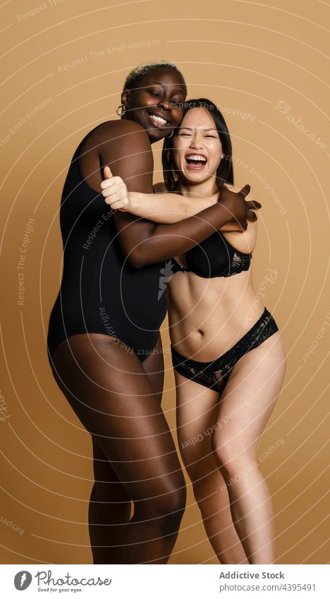 Cheerful diverse women in underwear embracing in studio hug body positive accept cheerful together confident embrace lingerie multiracial multiethnic black